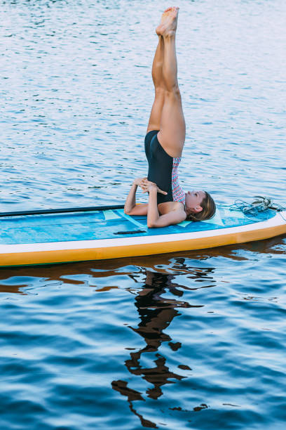 istock Woman on paddleboard with legs raised 2201283333