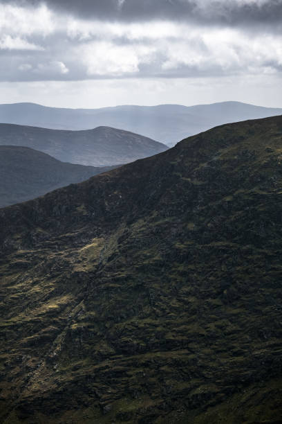 istock Stunning view of rolling mountains under soft cloudy sky in serene landscape. 2201291259