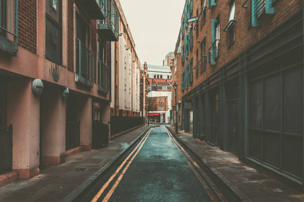 istock Deserted backstreet with yellow lines leading to distant buildings 2201297842