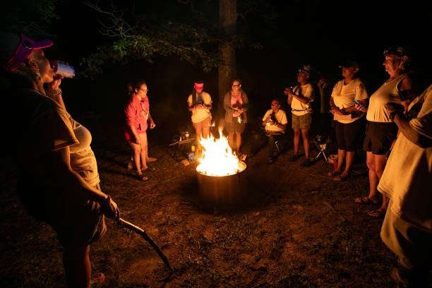 group of women bond as they gather around the camp fire at night to share stories