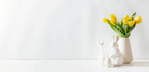 istock A white vase of yellow tulips and eggs on a white table 2201306454