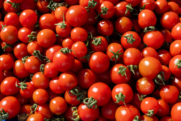 istock Fresh red cherry tomatoes piled at a local market during sunny midday hours 2201308969