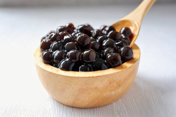 istock Black pearls for bubble mllk tea in a wooden bowl on white background 2201309837