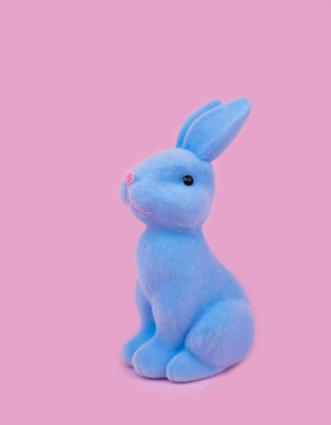 istock Decorative Easter Bunny of blue color on a pink background. Easter decor. Close-up. Selective focus. 2201310118