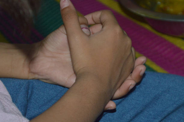 istock Close up of a woman's hands holding a child's hand. 2201317461