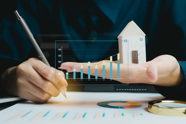 istock Businessman Analyzing Data with Graphs and House Model in Office, business concept 2201318660