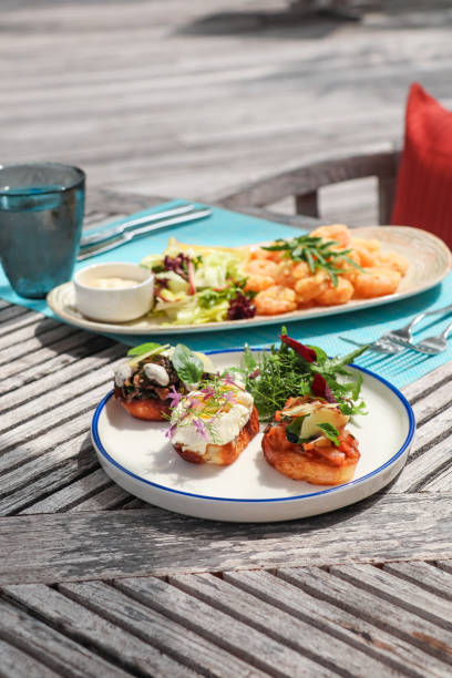 Beach Side restaurant shack serving lunch food snacks with prawns and bruschetta bread in tropical Maldives island resort