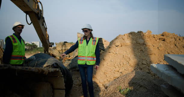 istock the male and female senior project Engineers or technicians inspect pipe circulars. Checking Construction of the water, drainage, sewer, and transport Pipeline work under a huge tube at the construction site. 2201324619