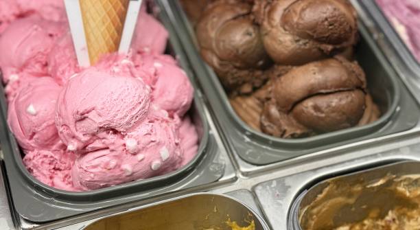 An inviting and delightful selection of colorful and various ice cream flavors is beautifully served in a display case. Close-up