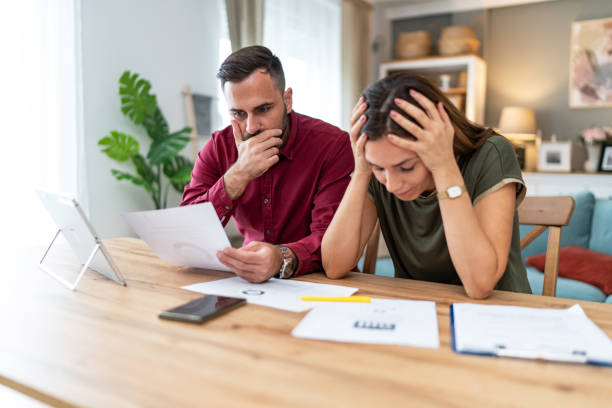 istock Worried couple having problems with their financial bills at home 2201325324