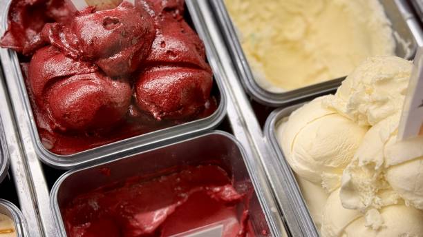 An inviting and delightful selection of colorful and various ice cream flavors is beautifully served in a display case. Close-up