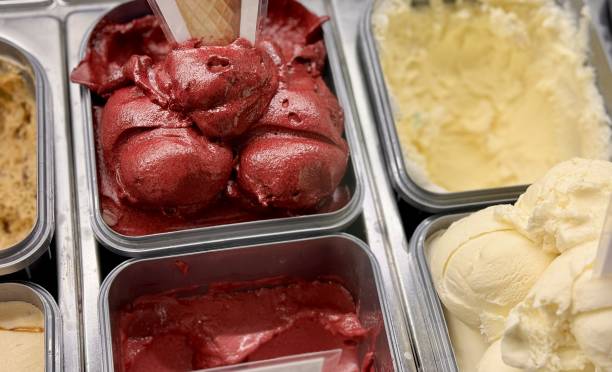 An inviting and delightful selection of colorful and various ice cream flavors is beautifully served in a display case. Close-up