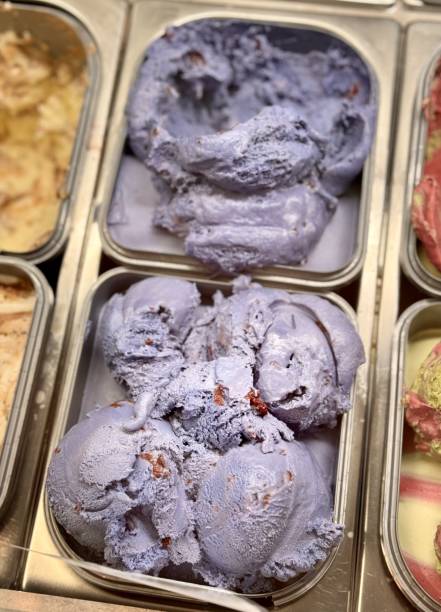 An inviting and delightful selection of colorful and various ice cream flavors is beautifully served in a display case. Close-up