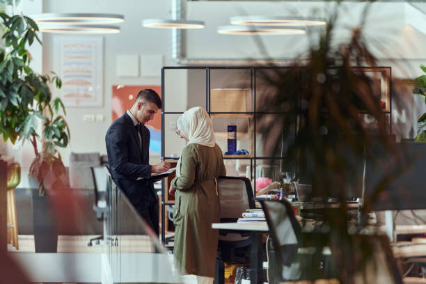 istock In the progressive setting of a modern startup office, the director engages in a discussion with a businesswoman wearing a hijab, illustrating inclusive dialogue, empowerment, and the dynamic nature of contemporary corporate interactions 2201331240