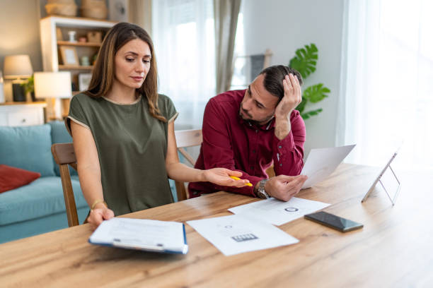 istock Displeased couple having problems with financial bills at home 2201331733