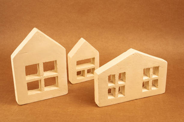 istock Miniature residential structures representing property market, investment potential, and homeownership against neutral brown backdrop 2201332094