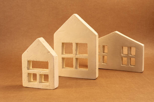 istock Miniature white houses resting on brown surface, symbolizing real estate market dynamics and property investment concept 2201332114