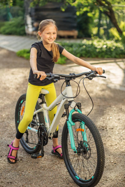 istock Child enjoying sunny day while riding her bicycle in park 2201333642