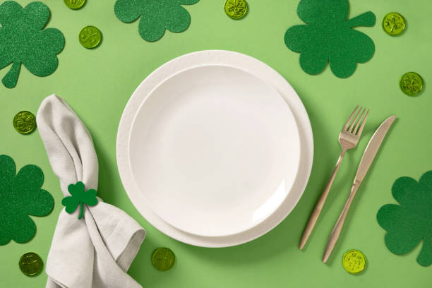 istock St Patrick's Day party table setting with green decoration on green background. 2201334508