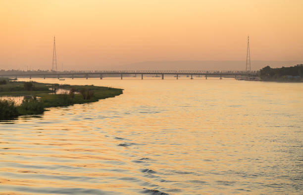 Wake of cruise ship on River Nile as it leaves Qena and road bridge to sail south to Luxor