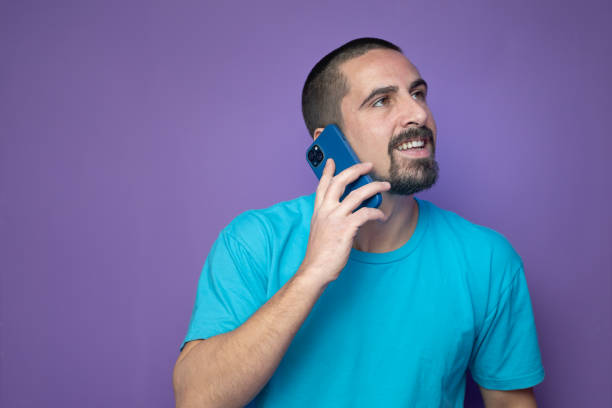 istock Happy young man talking with mobile phone on color background 2201354475