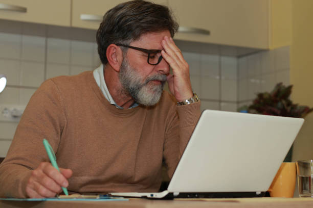 istock Emotional stress while working senior man online in living room 2201358519