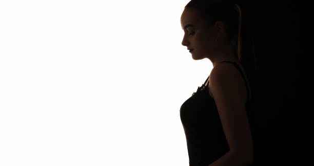 Female silhouette. Peaceful beauty. Dark profile outline of tranquil calm tender woman isolated on white copy space background.