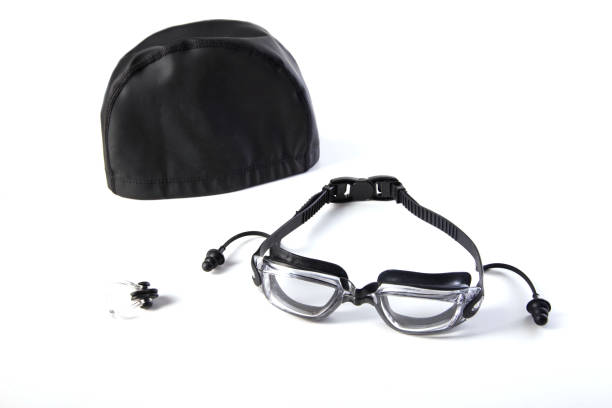 Black swimming cap, nose clip and ear plugs on a white background