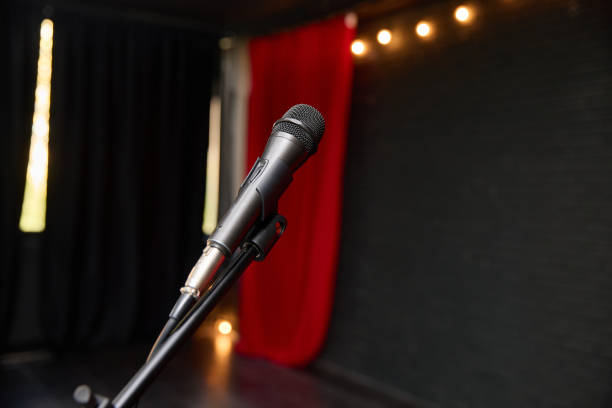 Closeup of a shiny microphone on stage, ready for an engaging performance under soft, atmospheric lights
