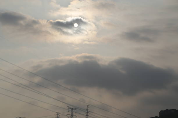 The sky is cloudy and the sun is shining through the clouds. The sun is a small, bright spot in the sky
