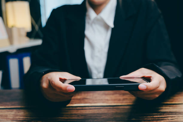 istock Person Holding Modern Mobile Device in Stylish Office Setting, business concept 2201409068