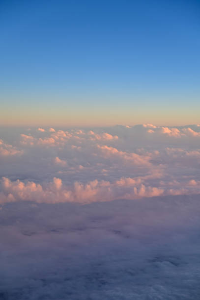 Looking through the airplane window with the sunset sky. Romantic sky, golden hours, colorful sunset sky with clouds. Stunning cloudscape and skyscape. Nature concept. For background use.