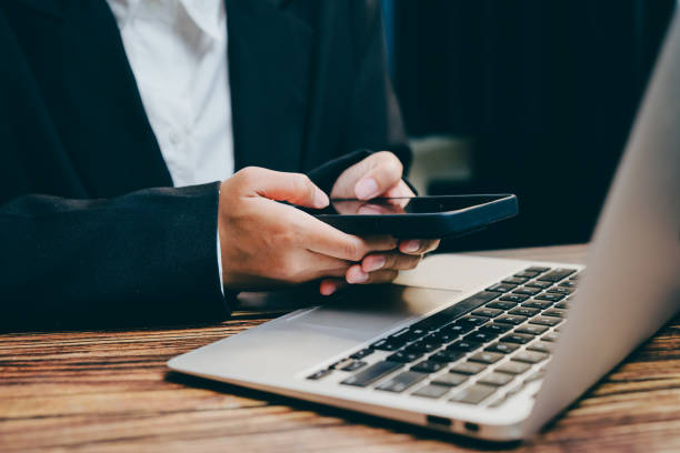 istock Business Professional Using Smartphone While Working on Laptop, business concept 2201413456