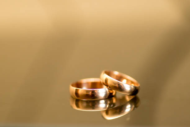 two wedding rings lie on a gold wedding background.