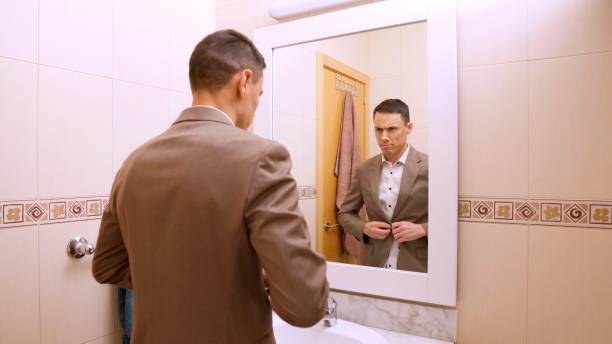 istock Businessman buttoning his jacket in the bathroom mirror 2201421684
