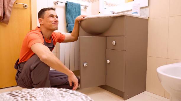 istock Plumber inspecting and repairing bathroom sink cabinet 2201421887