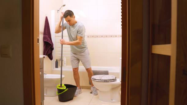 istock Man cleaning bathroom floor at home with mop 2201421950