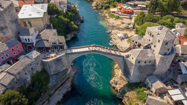 Top view of famous Mostar bridge. Aerial landscape view of tourist attraction with city background in summer