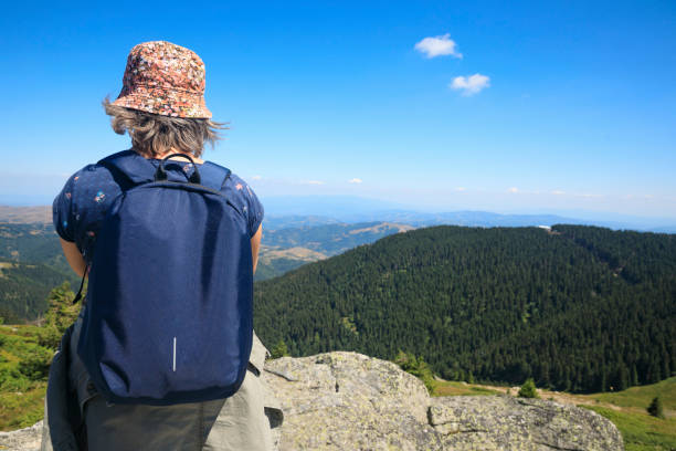 Rear view woman with backpack  enjoying Beautiful view of, Summer on the mountain, Kopaonik