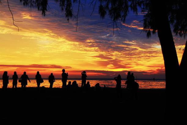 istock A group of people in silhouette standing looking at the sunset. 2201430602