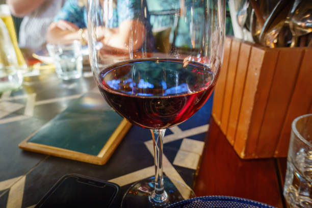 istock Red wine glass in a restaurant. Unrecognizable people in the background. Auckland. 2201430936