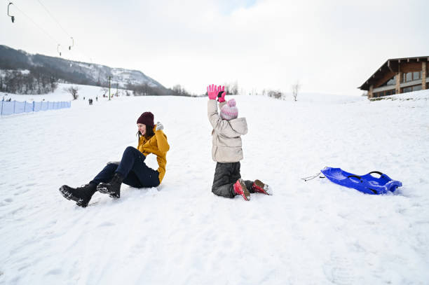 Little girl and boy enjoying sleigh ride. Child sledding. Brother and sister riding a sledge. Children play outdoors in snow. Kids sled in snowy park in winter. Outdoor fun for family vacation.