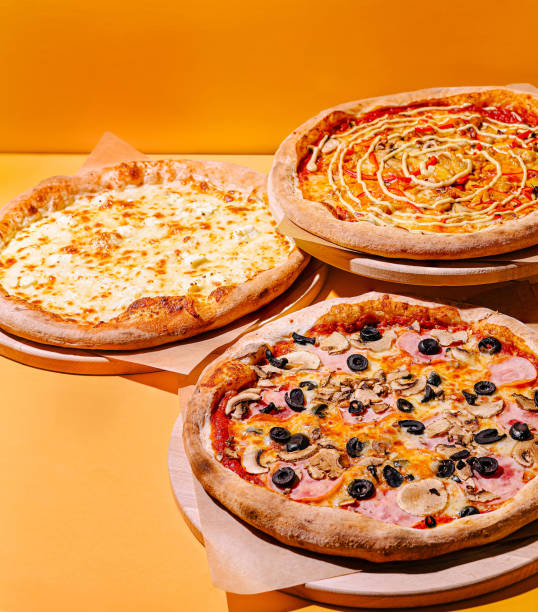 istock Delicious pizzas and crispy fries displayed on a bright yellow background, perfect for any gathering or celebration 2201434247