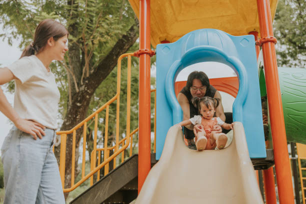 istock Father supported kid to play sliding equipment 2201434348