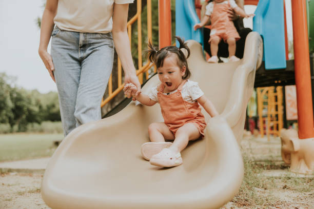 istock Playground Fun: Helping little Toddler Down the Slide 2201434377