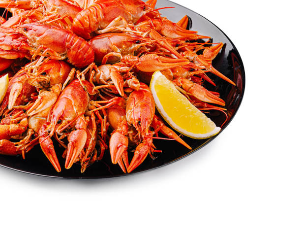 istock Deliciously prepared crayfish served on a black platter with lemon wedges at a seafood feast 2201434565
