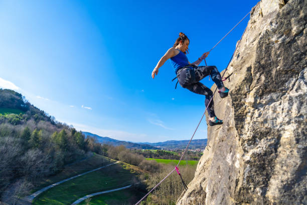 istock Young woman rock climbing on mountain in nature 2201435803