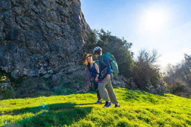 istock Climbers walking on grassy hillside near rock face 2201435908