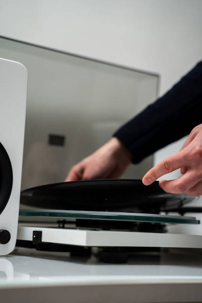 istock Setting up vinyl speaker system. Musicians hands adjusting vinyl disc on a needle player close-up. 2201438131
