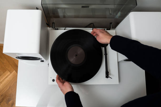 istock Musicians hands adjusting vinyl disc on a needle player close-up. Setting up vinyl speaker system. 2201438132